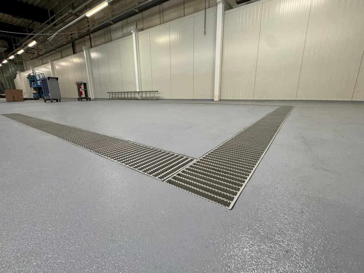 Canal de drenaje de 300 mm de ancho con cubierta de rejilla de escalera en una fábrica farmacéutica