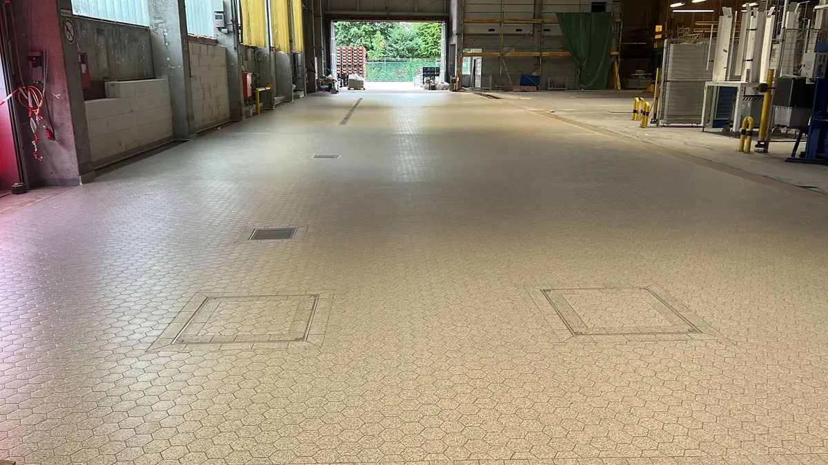 Suelo industrial de baldosas equipado con canales de drenaje, desagües de suelo y tapas de inspección