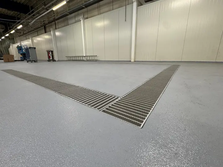 Canal de drenaje de 300 mm de ancho con cubierta de rejilla de escalera en una fábrica farmacéutica